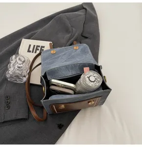 Λεπτομέρεια μίνι τσάντας πλάτης denim που δείχνει εσωτερική χωρητικότητα και δέρμα.
