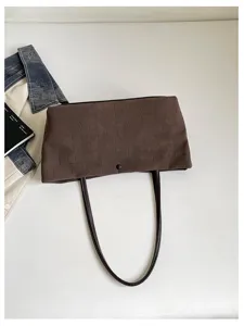 Dettaglio della borsa a spalla marrone effetto coccodrillo, elegante borsa minimalista.