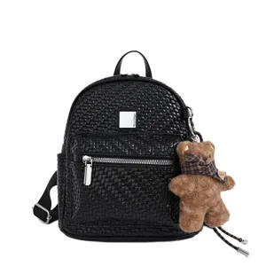 Detailed view of black woven texture leather backpack with cute fluffy bear pendant charm.