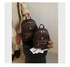 Detailed view of women's woven leather backpack showcasing fine texture, zippers and pockets.
