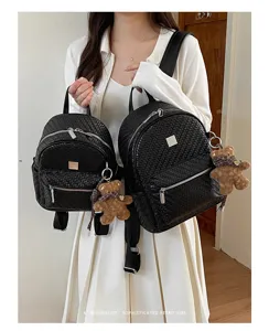 Black woven backpack detail showing dual sizes and cute bear pendant for daily commuting.