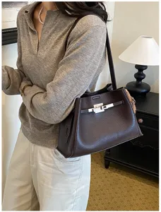 Brown leather shoulder bag for women, stylish structured handbag with turn-lock closure.