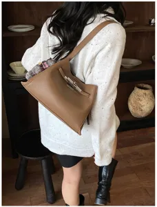 Detailed view of the stylish brown leather shoulder bag, chic hardware and daily casual wear.