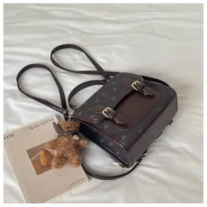Close-up detail of the retro contrast color backpack featuring a cute bear pendant and buckle.