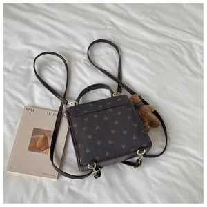 Chic brown heart pattern backpack with plush bear pendant, casual women travel small bag.