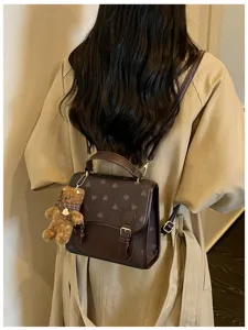 Stylish fashion mini backpack featuring cute heart patterns and an adorable bear plush pendant.