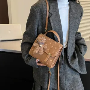 Stylish autumn winter retro canvas shoulder bag with cute bear pendant and top handle for women.