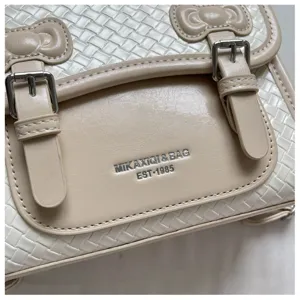 Detalle de mochila estilo universitario tejido retro, cuero PU con lindos lazos y hebillas metálicas.