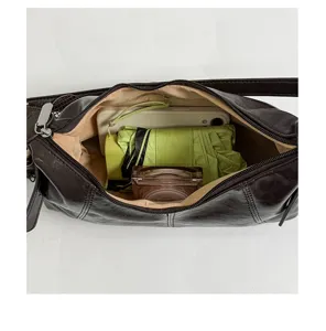 Dark brown leather shoulder bag interior detail showing spacious capacity with daily essentials inside.
