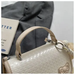 Bolso de mano tejido chic en beige con detalle de lazo elegante y herrajes de calidad.