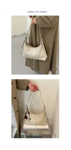 Minimalist beige hobo shoulder bag for women, chic casual commuter crossbody bag with charm.