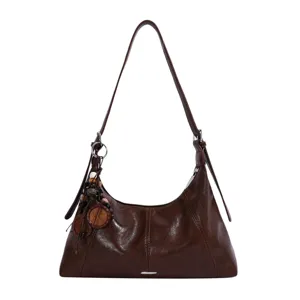 Detailed view of the brown leather shoulder bag, hobo style with chic beaded charms.