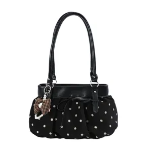 Close-up detail of the black polka dot faux suede underarm bag with cute bow and pearl pendant.