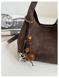 Détail de sac porté épaule croissant en suédine marron, style coréen sac besace tendance femme.