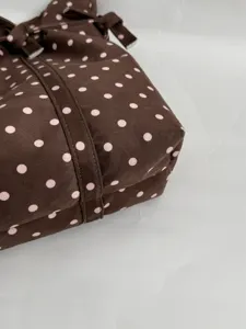 Brown polka dot shoulder bag detail closeup, soft fabric casual daily tote accessory for women
