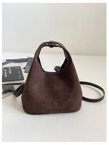 Vue détaillée du sac bandoulière croissant en daim marron montrant sa texture douce et anse.