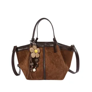 Brown suede patchwork bucket bag with floral pendant, stylish commuter shoulder crossbody bag.