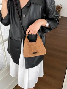 Vue détaillée du sac hobo croissant chic en suédine marron, avec texture douce et bandoulière.
