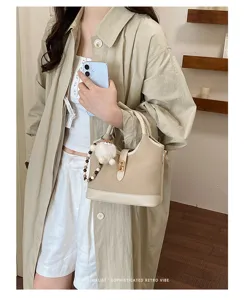 Retro beige bucket bag for women, stylish PU canvas handbag with metal lock and cute charm.