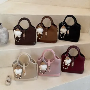 Vintage bucket bag with plush charm and chic top handle, stylish commuter shoulder handbag.
