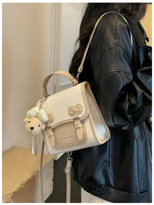 Mochila estilo universitario para mujer detalle con textura tejida y dije de osito.
