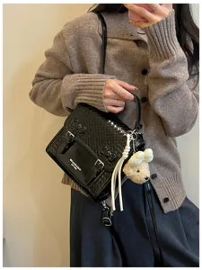 Bolso de mano vintage de charol negro con lindo dije de osito y textura tejida.