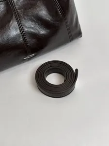 Dark brown leather underarm shoulder bag and strap detail shot, casual commuting crossbody bag