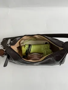 Minimalist brown leather hobo shoulder bag detail showcasing spacious interior capacity.