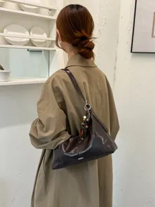 Close-up detail of stylish Korean style brown shoulder hobo bag with beaded charm decoration.