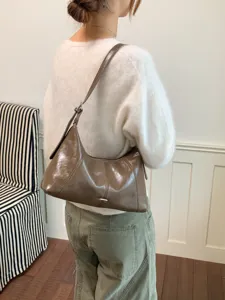 Glossy brown hobo shoulder bag detail, elegant minimalist daily commuter style fashion.