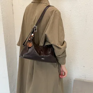 Stylish retro brown shoulder bag for women, casual commuter hobo dumpling handbag with charm.