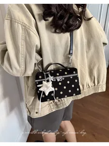 Black polka dot vanity shoulder bag with top handle and star charm for women daily use.