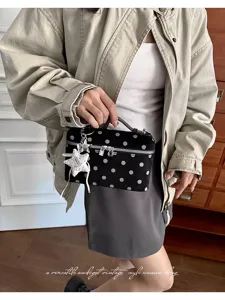 Detailed view of vintage polka dot handbag featuring star charm and delicate zipper design.