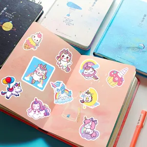 Gros plan d'autocollants de licornes de dessin animé mignons sur un carnet. Coloré et beau.