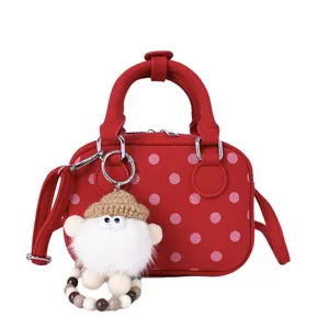 Red polka dot bowling bag detail showcasing cute fluffy doll keychain and textured fabric.