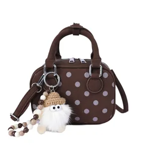 Retro brown polka dot suede bowling bag detail, featuring cute gnome charm and metal hardware.