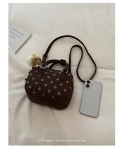 Retro brown polka dot bowling bag with suede finish, top handle and crossbody strap.