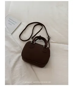 Detailed look at the dark brown suede retro shoulder bag showcasing refined metal hardware.