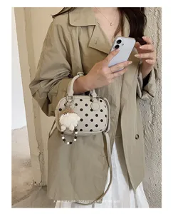 Retro polka dot bowling shoulder bag with furry charm, trendy faux suede crossbody handbag.