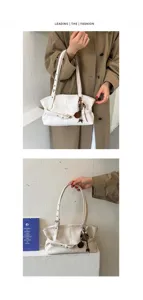 Vue détaillée du sac à épaule minimaliste blanc avec sangle élégante et charmant pendentif.