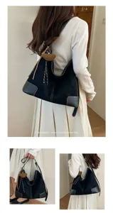 Casual minimalistische retro hobo schoudertas met contrasterende leren hoeken en bedel.