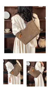 Detailed view of vintage brown suede shoulder tote bag with tassel charm and leather straps.