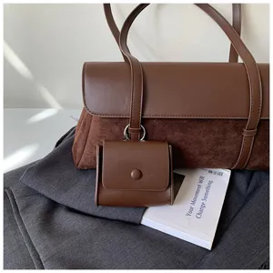 Detailed view of the retro brown leather suede shoulder bag with mini charm pouch. Chic style.
