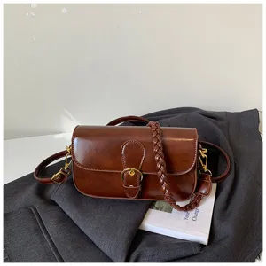Braune Leder-Achseltasche Detailansicht mit retro Metallschnalle und geflochtenem Riemendesign