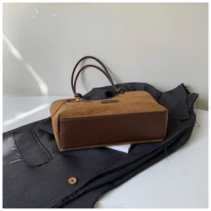 Retro brown suede tote bag detail view, showing exquisite stitching, premium leather contrast texture.