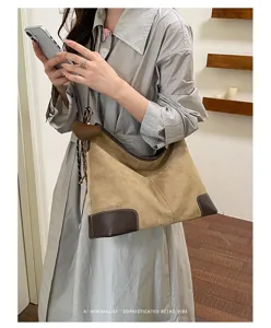 Detailopname van de suède hobo schoudertas voor dames, retro stijl met donkere hoeken.