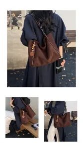 Brown suede hobo shoulder bag detailed with wooden bead tassel charm for daily commute and styling.