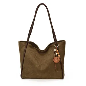 Brown suede tote bag detail, retro style shoulder bag with leather straps and wooden bead charm.