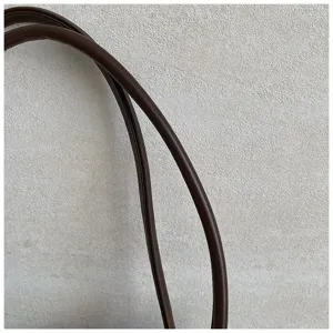 Close-up detail shot of dark brown leather handbag handle showing fine texture and neat stitching.