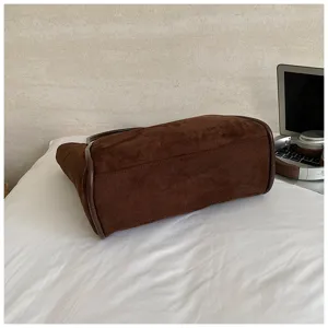 Detail view of brown suede commuter tote bag showcasing spacious capacity and refined trim.
